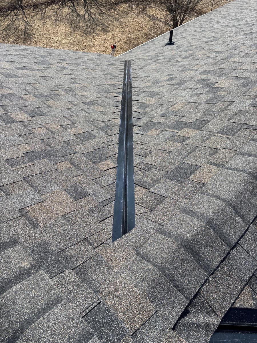 Open valley metal between two planes of new gray shingles on the St. Joseph roof