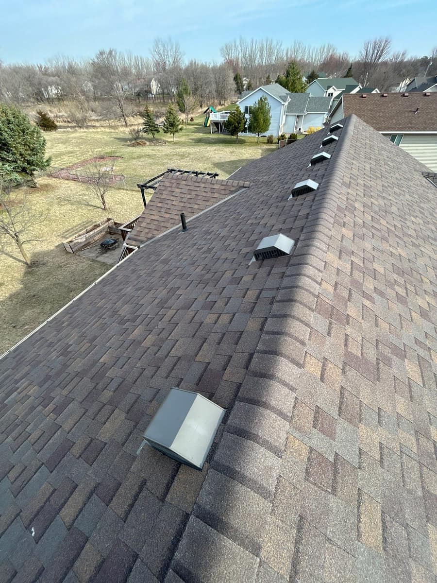 New brown blend shingle roof with a row of roof vents on a Waite Park, MN home