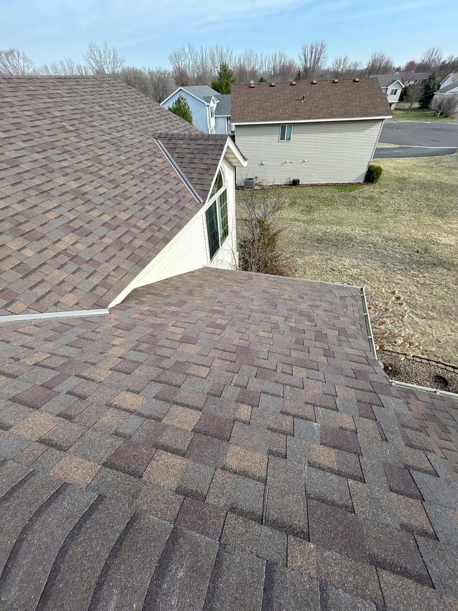 New shingles meeting a gable wall with step flashing in Waite Park