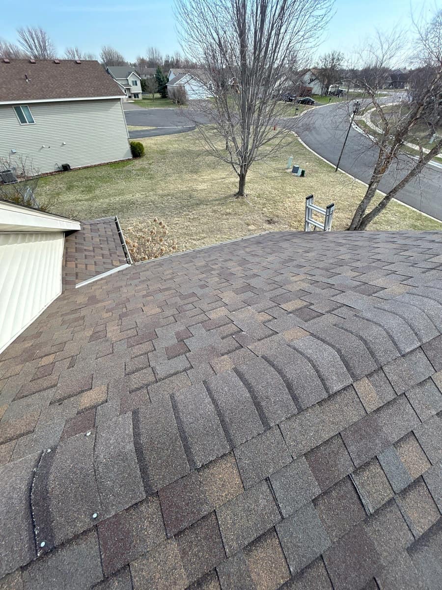 Rounded hip section of the new brown shingle roof in Waite Park