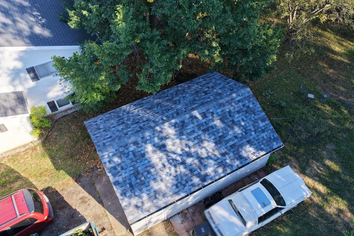 Drone view of a detached garage with a new shingle roof in Waite Park
