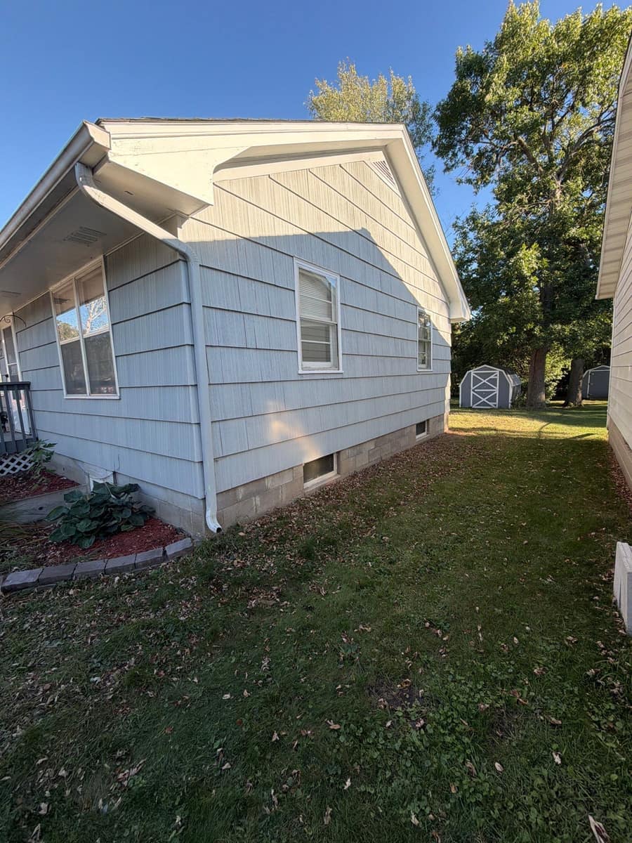Gable end of the Waite Park home with white siding under the new roof