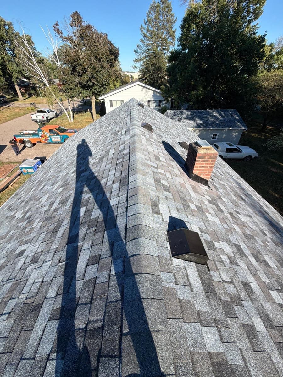 Ridge of the new shingle roof with a brick chimney in Waite Park